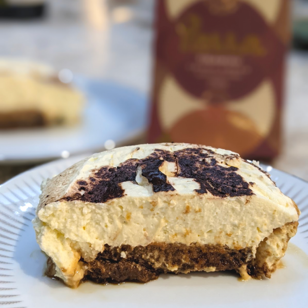 A cross section slice of Yalla tiramisu. One third is sponge, two thirds is cream cheese.