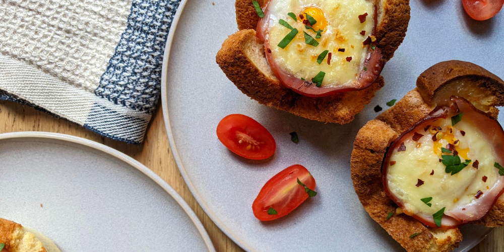 Breakfast egg cups on a plate with a side of tomatoes.