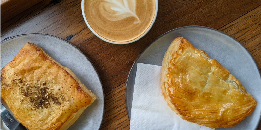 Two gluten free pastries and a flat white.
