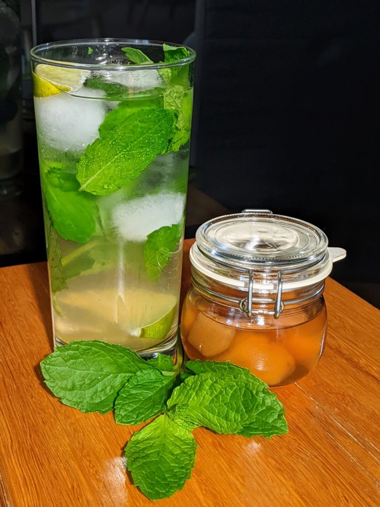 Ginger mojito a long glass filled with mint leaves, lime slices topped up with soda water. 