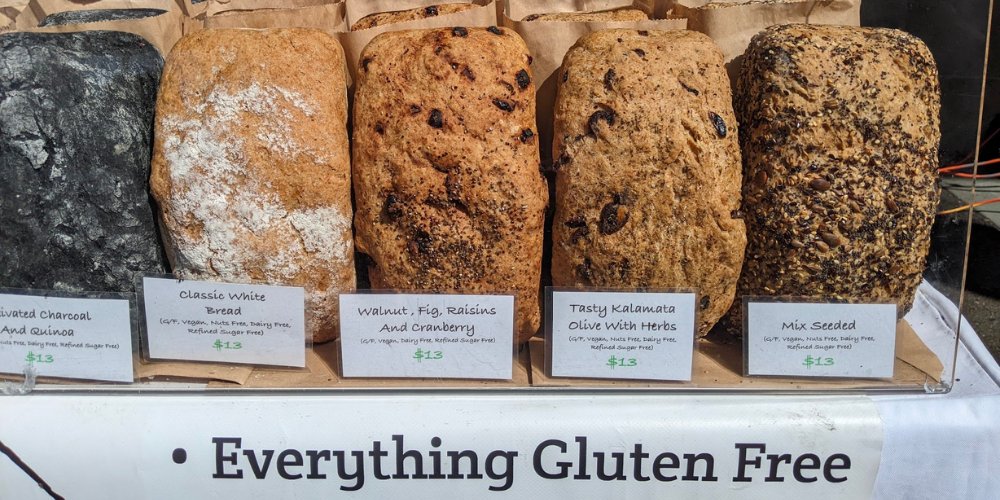 Five different loaves of gluten free bread by baker's chemistry. Charcoal quinoa, classic white, walnut fig raisins and cranberry, kalama and herbs, mix seeded.