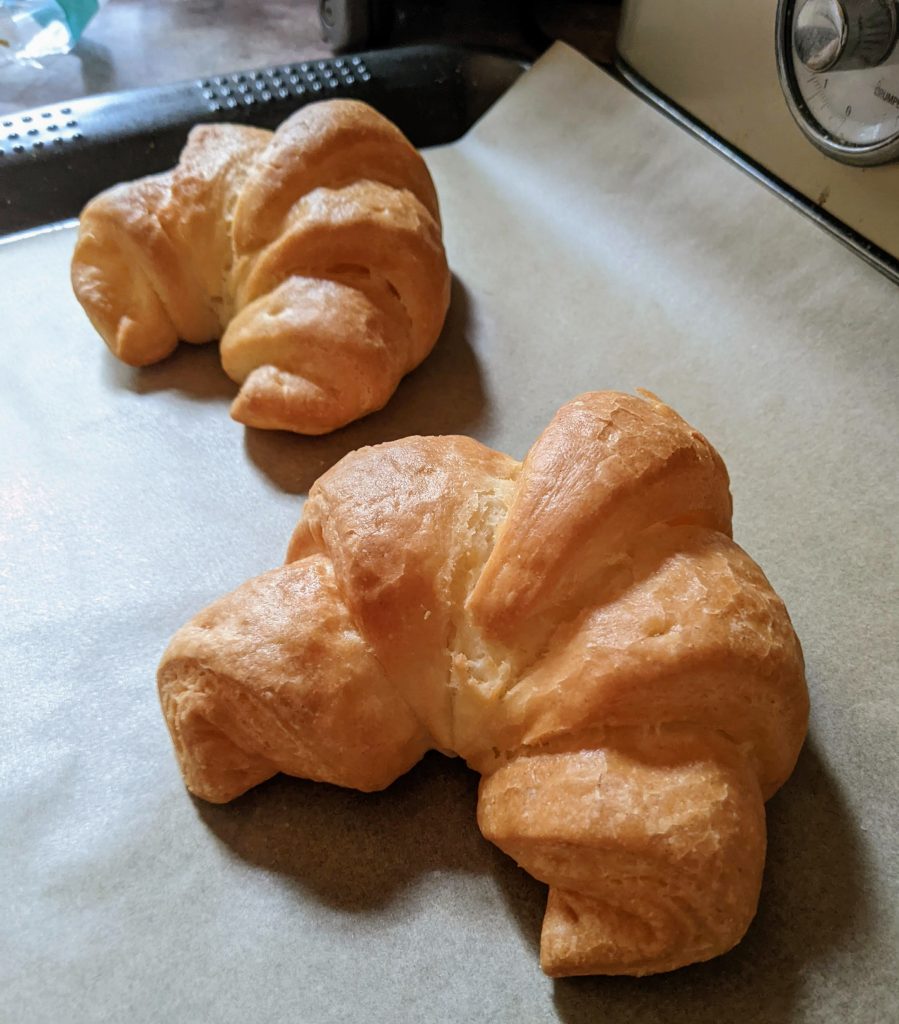Woolworths gluten free croissants on an oven tray. The colour is slightly darker than when they were in the packet. 