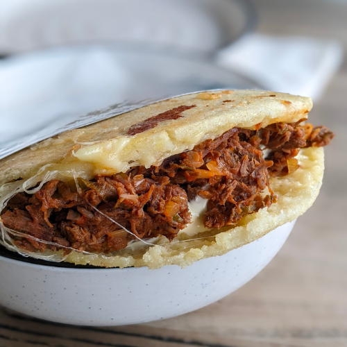 An arepa filled with pulled beef and cheese.