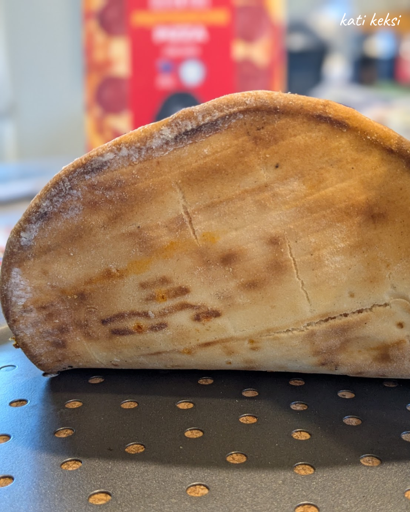 The underside of a pizza base showing it is well browned.