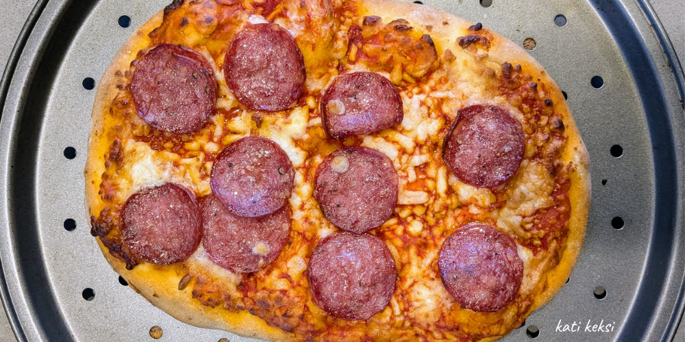 An arial view of a pepperoni pizza on a metal tray.